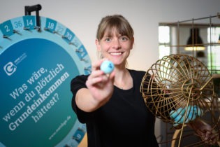 Mensch hinter Drehschreibe und Ball in der Hand