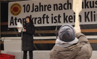 Furutani hält das Holz, Yu hält eine Rede auf der Bühne