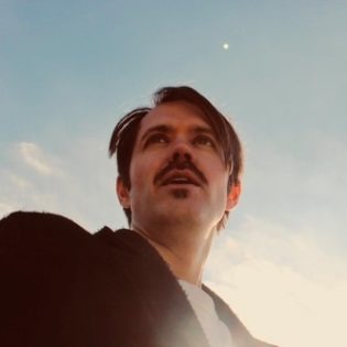 Cover von SCHWARZ – Sunscreen; Foto des Artists vor blauem Himmel und dem Mond ganz klein im Hintergrund